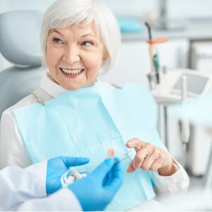 Smiling patient looking at dental implants