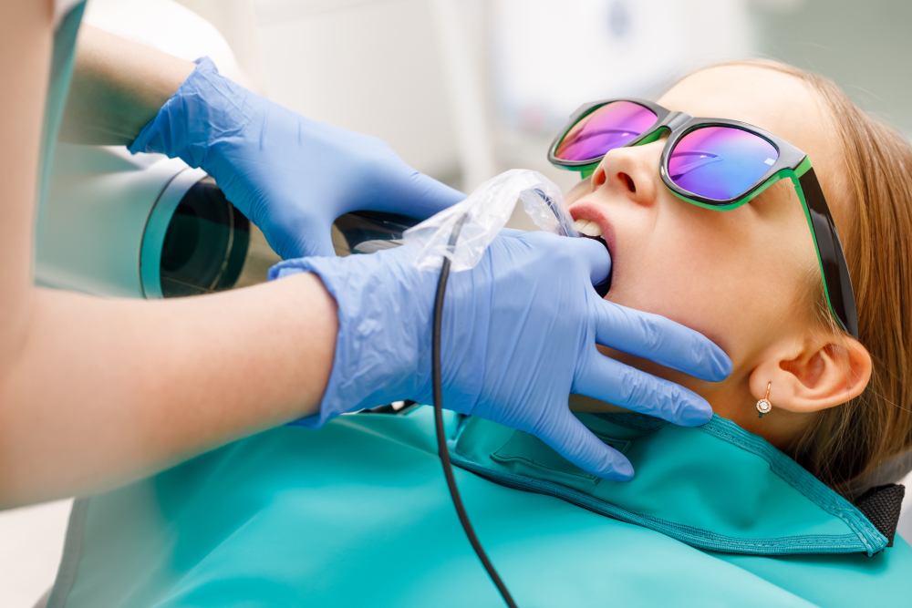 Young girl wearing sunglasses in the dental chair